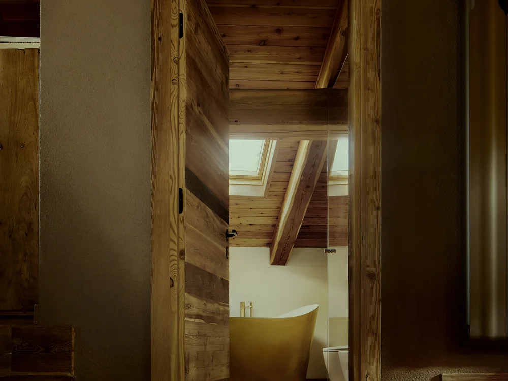 Baita Horres · Luxury Mountain Chalet · Bardonecchia Vista attraverso una porta in legno su un bagno con vasca freestanding e soffitto in legno