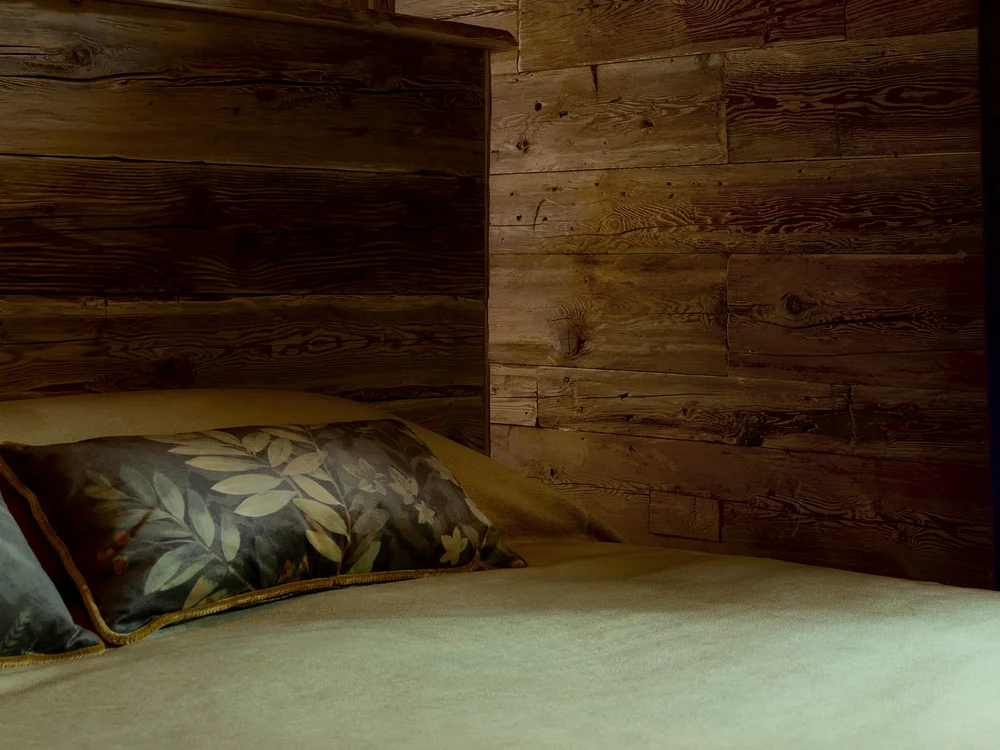 Baita Horres · Luxury Mountain Chalet · Bardonecchia Letto con cuscini a foglie in una camera rivestita in legno