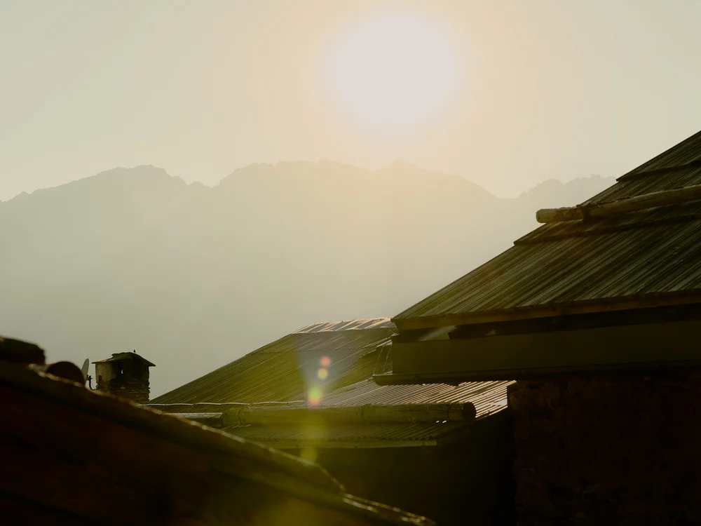 Baita Horres · Luxury Mountain Chalet · Bardonecchia Tetti in ombra al tramonto, con il sole che illumina montagne lontane