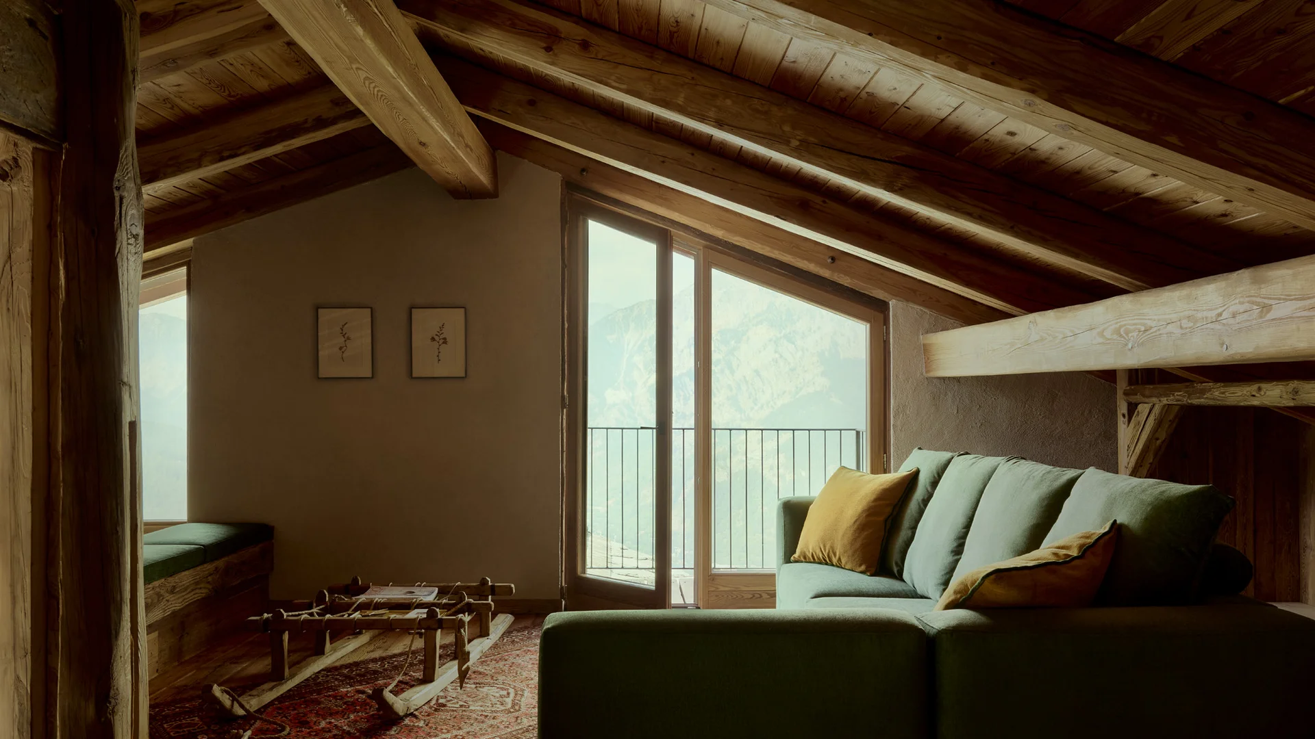 Soggiorno mansardato con travi in legno, divano verde e porte sul balcone con vista sulle montagne